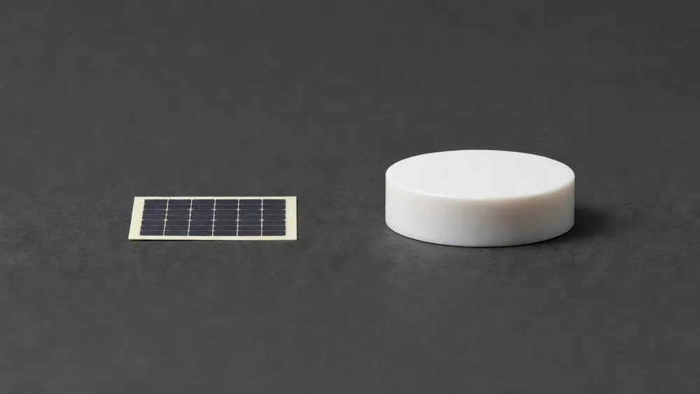 Side view comparing the FindStick's thin profile to a thick round battery tracker.