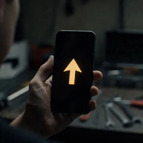 A phone showing a directional arrow pointing across a dim garage.